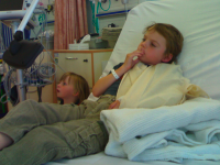 Me in a sling, with my telly monster brother in the background